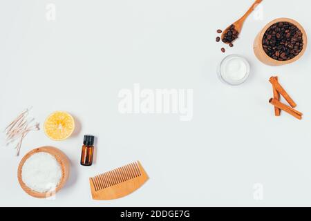Ingrédients pour gommage du corps maison avec grains de café, café et huile essentielle sur table blanche, vue du dessus. Banque D'Images