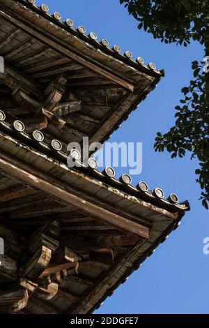 Détail du toit de Nandai-mon, la Grande porte sud du temple Todai-ji à Nara, Japon contre un ciel bleu par une journée ensoleillée. Banque D'Images