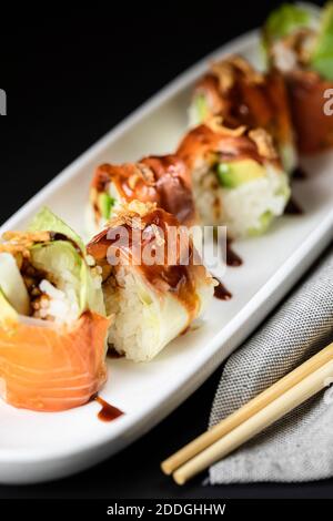 Gros plan des rouleaux appétissant remplis de navet frais et garnis avec sauce teriyaki Banque D'Images