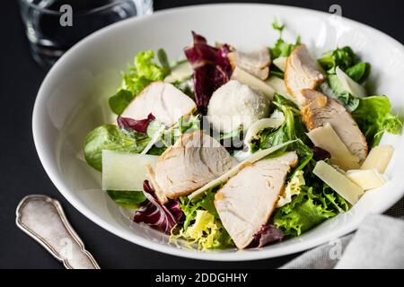 Gros plan sur une délicieuse salade César avec poulet et légumes servis à table dans le café Banque D'Images