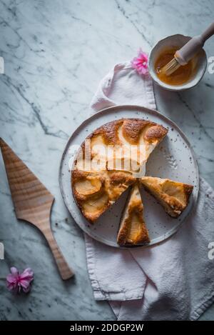 Composition avec vue de dessus et délicieux gâteaux aux pommes faits maison sur des assiettes placé sur la table avec un bol de sirop doux et de cuisson brosse Banque D'Images