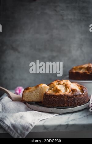 Composition de délicieux gâteaux aux pommes faits maison sur des assiettes placées dessus table avec bol, sirop doux et brosse de cuisson Banque D'Images