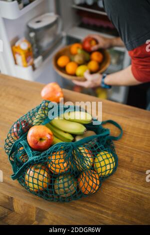 Sac en coton écologique avec fruits mûrs, grand angle placé sur la table dans la cuisine sur le fond de la crop-personne Banque D'Images