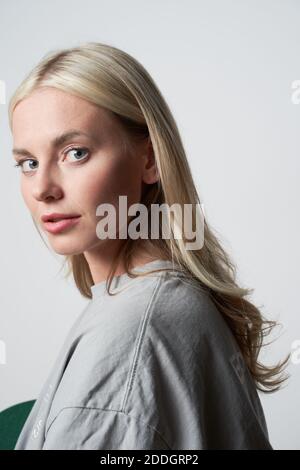 Jeune femme blonde fraîche avec tenue élégante sur fond gris et regarder l'appareil photo Banque D'Images