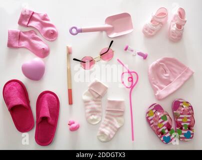 Concept de douche plate de bébé fille. Vêtements et accessoires de couleur rose pour nouveau-né sur fond blanc, vue du dessus. Banque D'Images