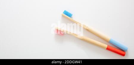 Brosses à dents en bambou rose et bleu isolées sur fond blanc. Écologique, zéro déchet, concept sans plastique. Hygiène personnelle des enfants, bannière Banque D'Images