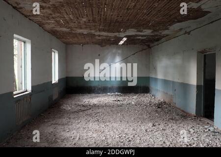 Chambre d'une maison abandonnée. Plafond qui s'écaille. Les murs de la chambre sont peints en blanc et bleu. Banque D'Images