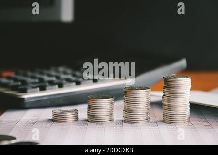 Piles de monnaie avec calculatrice et banque de livres, concept d'investissement financier. Banque D'Images
