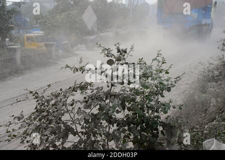 Les gens marchent sur une route poussiéreuse très fréquentée à Dhaka, au Bangladesh, le 25 novembre 2020. L'état de l'air de la ville de Dhaka s'aggrave jour après jour en cas d'alarme Banque D'Images