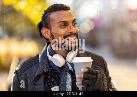 Beau jeune homme qui boit du café dans la rue Banque D'Images