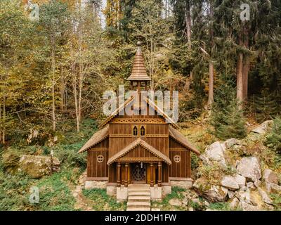 Pèlerinage en bois chapelle rurale de la Vierge Marie, CZ: Stozecka kaple et croix de fer debout dans la forêt à l'altitude de 950 m, République Tchèque, Sumava Na Banque D'Images