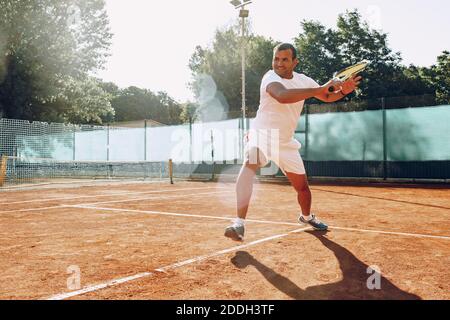 FIT man joue au tennis sur le terrain Banque D'Images