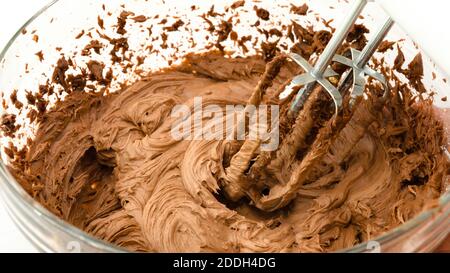 La crème de beurre au chocolat fondu se ferme dans un bol en verre Banque D'Images