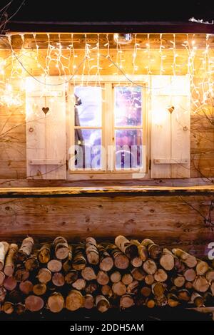 Fenêtre de cabine en bois dans la nuit de noël. Fête de noël de la nouvelle année, décoration de fenêtre d'accueil avec guirlande Banque D'Images