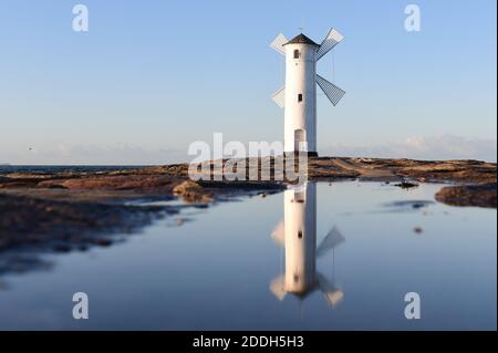 20 novembre 2020, Pologne, Swinemünde: La balise du moulin se reflète dans une flaque sur la jetée ouest. Photo: Sebastian Kahnert/dpa-Zentralbild Banque D'Images