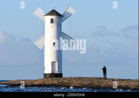 20 novembre 2020, Pologne, Swinemünde : un homme photographie le phare du moulin sur la jetée ouest. Photo: Sebastian Kahnert/dpa-Zentralbild Banque D'Images