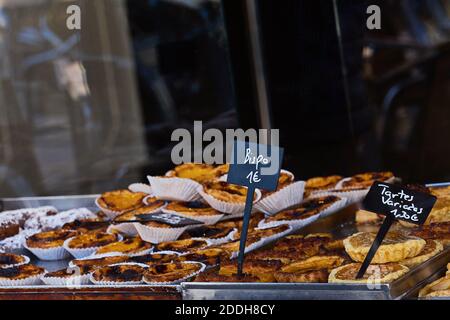 Vitrine d'une boulangerie confortable avec une variété de pâtisseries, de biscuits et de tartes. Inscription en portugais : eclair, gâteau, chocolat, meringue, pain Banque D'Images