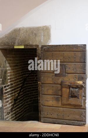Une ancienne porte en bois avec un péephole, ruinée, protège les escaliers vers le toit de Castillet. Banque D'Images