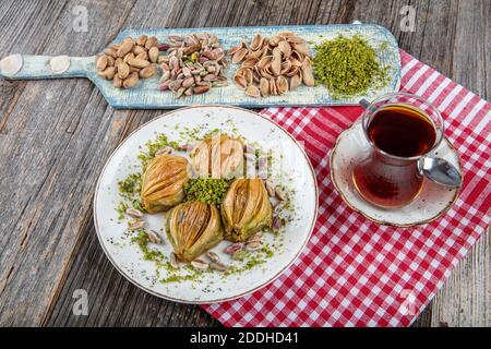 Baklava Midye turque ( Baklava en forme de mussel ) avec poudre de pistache verte et crème au beurre. Conceptuel des fêtes islamiques. Banque D'Images