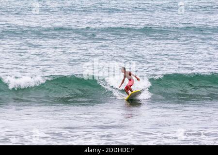 Un surfeur sur les vagues à Baler, Philippines Banque D'Images