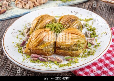 Baklava Midye turque ( Baklava en forme de mussel ) avec poudre de pistache verte et crème au beurre. Conceptuel des fêtes islamiques. Banque D'Images