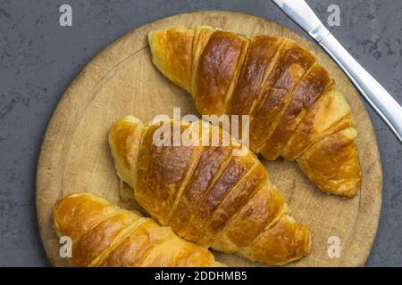 Trois croissants sur une planche en bois - vue du dessus gros plan Banque D'Images