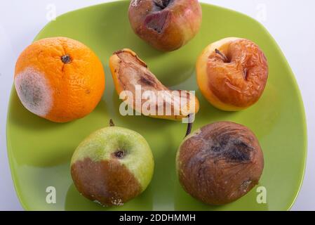 Fruits gâtés sur une assiette, sur fond blanc fraises Rotten sur fond blanc Banque D'Images