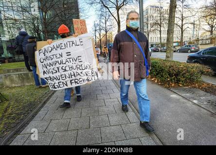 Munich, Bavière, Allemagne. 25 novembre 2020. WOLFGANG HERING à côté d'un panneau tenu par un manifestant pro-choix contre son groupe fondamentaliste chrétien.à l'occasion de la Journée internationale contre la violence contre les femmes, le groupe ultra-conservateur anti-avortement Helfer fÃÂ¼r Gottes kostbare Kinder (''Helper for God's Precious Children') Dirigé par Wolfgang Hering a organisé une marche de protestation après une séance de prière officielle à l'intérieur de l'église Saint-Paul. Deux étudiants protestants se sont joints en chemin, indignés par ce qu'ils affirment, c'est la désautonomisation des femmes du groupe et les actions contre l'autodétermination, y compris Banque D'Images