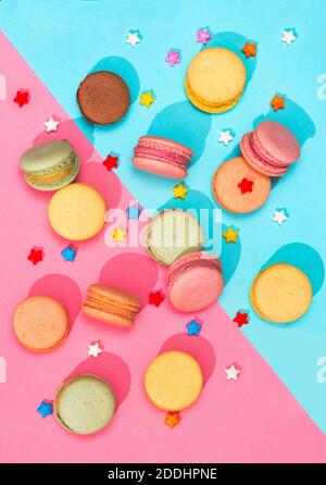 Macarons bonbons de différentes couleurs placés sur un rose et Macarons colorés à motif bleu Banque D'Images