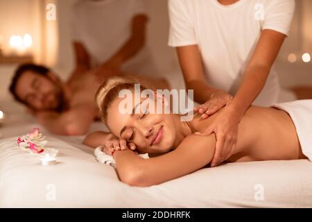 Un couple heureux se détendant au spa de luxe et recevant un massage du dos Banque D'Images