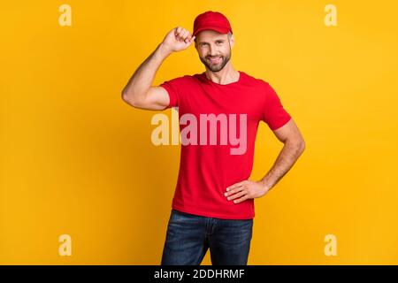 Photo d'homme barbu gai look appareil photo Toothy sourire usure t-shirt rouge chapeau isolé couleur jaune fond Banque D'Images