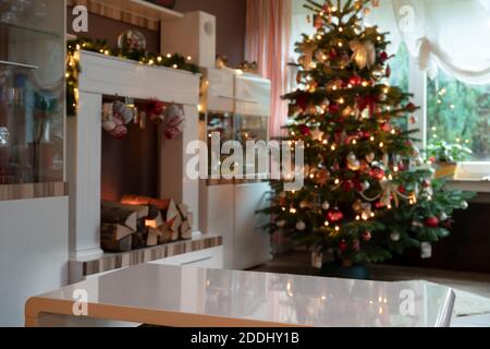 Modèle de salon à la décoration festive à Noël. Foyer et arbre de Noël sont hors foyer. Au premier plan se trouve une table blanche vide sur Banque D'Images