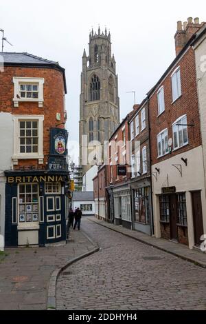 Le long de Church St, passez la maison publique Britannia en direction de la tour de l'église St Botolph à Boston, Lincolnshire, Royaume-Uni. Banque D'Images