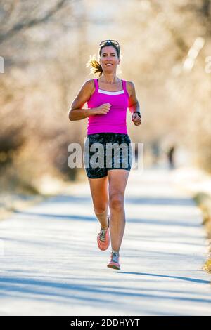 Attrayant; d'âge moyen; femme en forme qui court sur un sentier pavé; Salida; Colorado; États-Unis Banque D'Images