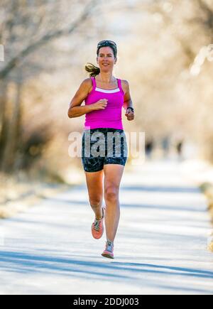 Attrayant; d'âge moyen; femme en forme qui court sur un sentier pavé; Salida; Colorado; États-Unis Banque D'Images