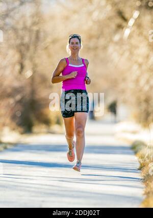 Attrayant; d'âge moyen; femme en forme qui court sur un sentier pavé; Salida; Colorado; États-Unis Banque D'Images