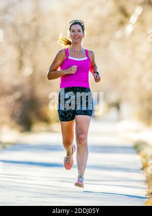 Attrayant; d'âge moyen; femme en forme qui court sur un sentier pavé; Salida; Colorado; États-Unis Banque D'Images