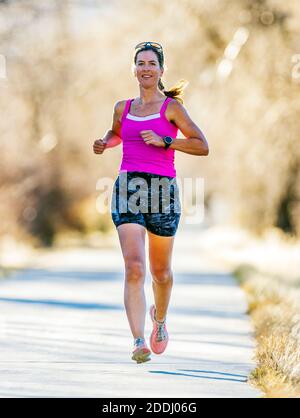 Attrayant; d'âge moyen; femme en forme qui court sur un sentier pavé; Salida; Colorado; États-Unis Banque D'Images
