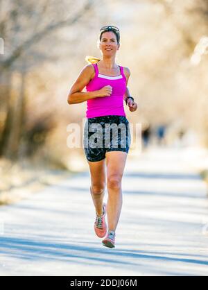 Attrayant; d'âge moyen; femme en forme qui court sur un sentier pavé; Salida; Colorado; États-Unis Banque D'Images