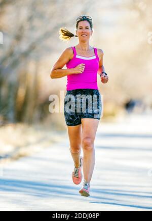 Attrayant; d'âge moyen; femme en forme qui court sur un sentier pavé; Salida; Colorado; États-Unis Banque D'Images