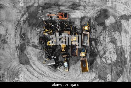 Des machines lourdes, y compris des camions jaunes, dans l'environnement de travail dans une mine d'agrégats, vues dans une photo aérienne prise d'un drone Banque D'Images