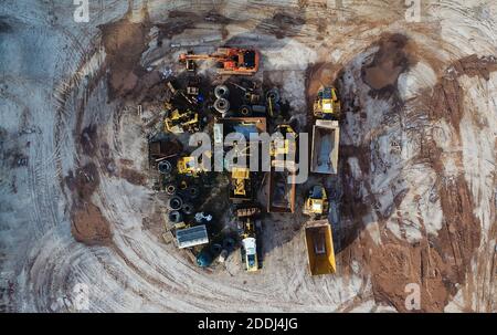 Des machines lourdes, y compris des camions jaunes, dans l'environnement de travail dans une mine d'agrégats, vues dans une photo aérienne prise d'un drone Banque D'Images