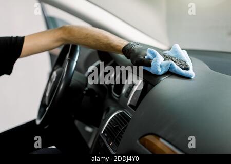 Nettoyage de la voiture, concept de détail, lavage de voiture. Gros plan sur une coupe courte des mains d'un travailleur masculin professionnel, portant des gants en caoutchouc, nettoyant le Banque D'Images