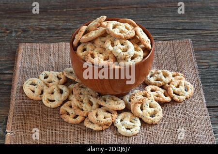 Bretzels au fromage et aux graines dans un bol sur une ancienne table en bois. En-cas salé pour la bière Banque D'Images