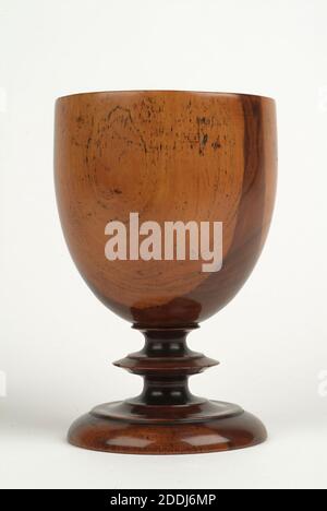 Coupe, goblet, 1700-1800, fabriquée en Angleterre. Ce gobelet en bois de laburnum est l'un des deux, probablement datant du XVIIIe siècle. On peut dire qu'il a été fait sur un tour de poteau parce que le point où le gobelet a été tenu en place sur le tour laisse une marque caractéristique sur la base. Il est très difficile de dater ces gobelets en bois simple avec précision, car les styles et les modèles ont changé très lentement au fil des ans. Le bois de Laburnum était un choix intéressant pour ce gobelet car ses tons chauds et son coeur sombre contrasté et son aubier jaune contribuent à ajouter une certaine beauté et finesse Banque D'Images