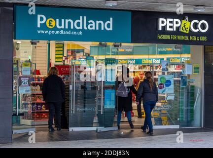 les acheteurs qui entrent dans une succursale du centre-ville de la grande rue de la chaîne de vente au détail de la zone de fond avec une grande bannière de marque de zone de fond. Banque D'Images