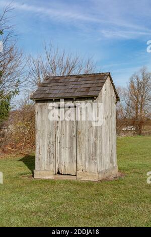 Ancien Outhouse déserté situé près d'une école d'une pièce abandonnée. Rural Illinois, États-Unis. Banque D'Images