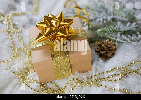 magnifique boîte cadeau dorée ornée d'un noeud sur la neige pour le nouvel an et noël avec des décorations et un arbre de noël Banque D'Images