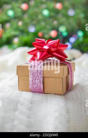 magnifique boîte cadeau surprise festive ornée d'un noeud rouge Un arrière-plan bokeh et près de l'arbre de Noël pour nouveau année et saint-valentin Banque D'Images