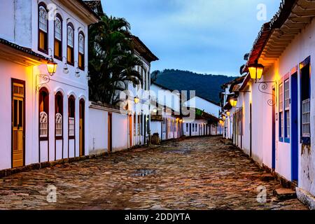 Vue sur la ville historique de Paraty au crépuscule avec l'éclairage de ses rues pavées et maisons déjà illuminées Banque D'Images